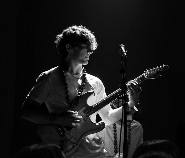 Connor Fiehler playing guitar on stage with 2023 American Idol winner Iam Tongi